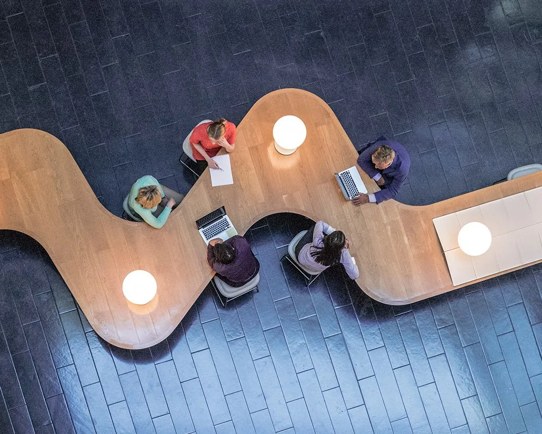 Persone sedute a un tavolo che collaborano nel lavoro