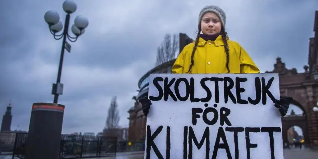Attivista Greta Thunberg con cartello davanti al parlamento Svedese